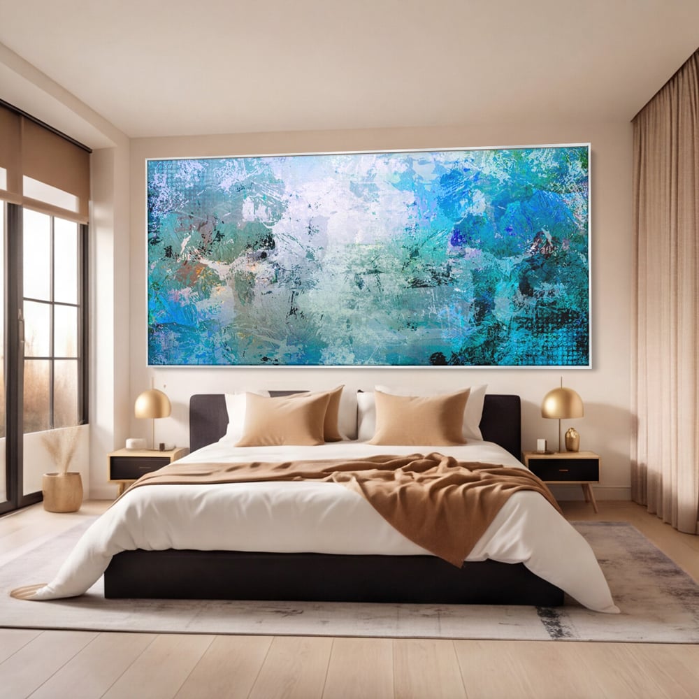 Tablou canvas cu pictura abstracta cu pete de albastru, in rama de aluminiu argintiu, pe perete intr-un dormitor